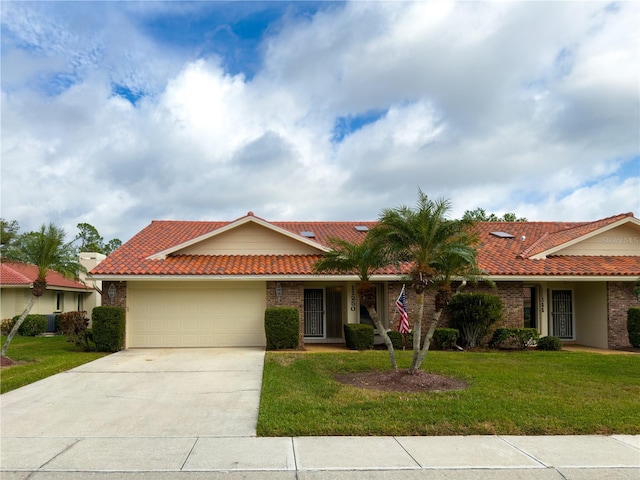 single story home featuring a front lawn and a garage