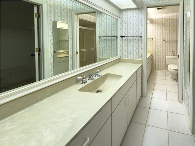 bathroom with toilet, tile patterned floors, and vanity