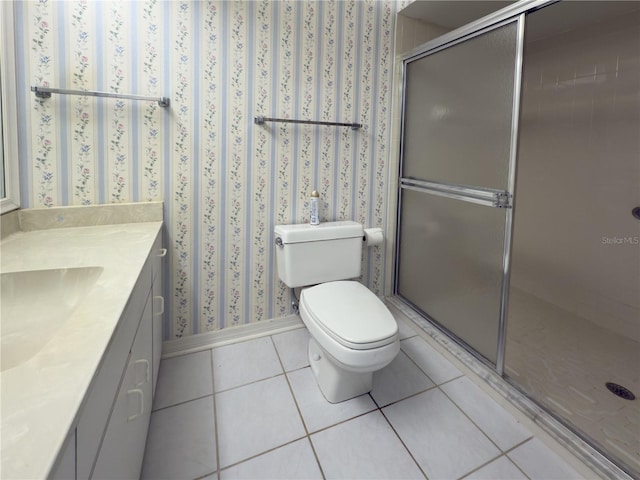 bathroom featuring toilet, vanity, an enclosed shower, and tile patterned flooring