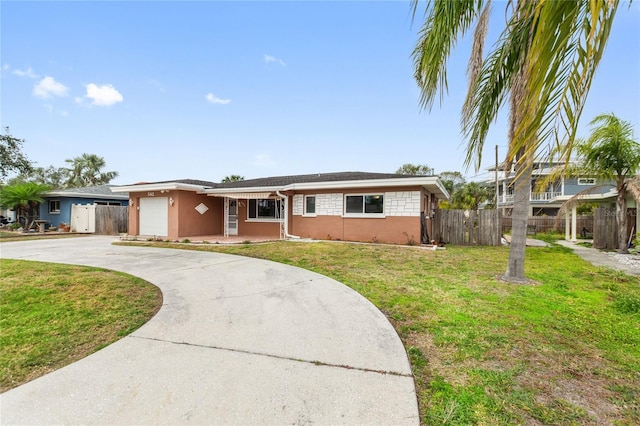 single story home featuring a garage and a front lawn