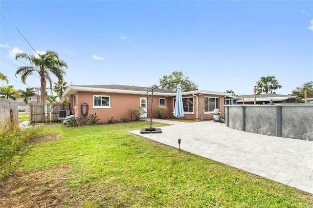 rear view of property featuring a patio area and a lawn