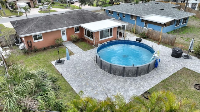 view of pool featuring a lawn and a sunroom