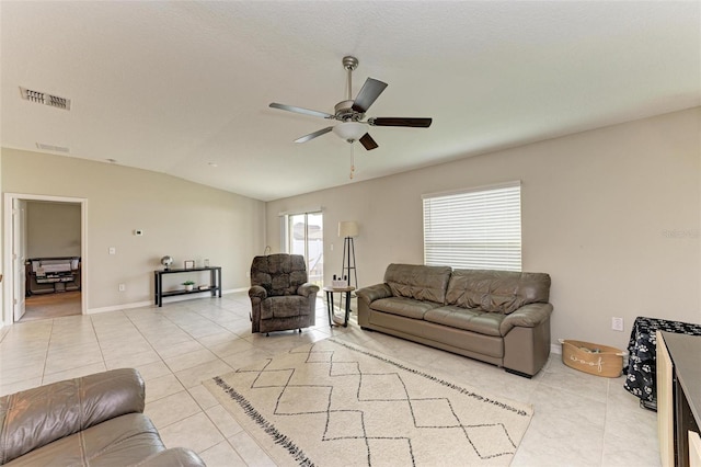 living room with ceiling fan, light tile patterned floors, and lofted ceiling