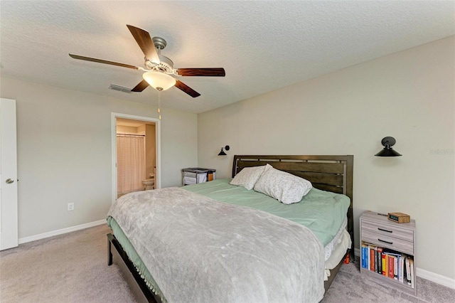 bedroom with ceiling fan, light carpet, and a textured ceiling