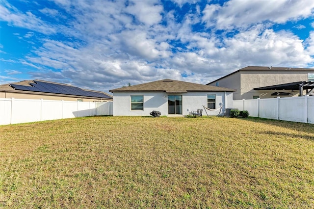 back of property featuring central AC and a yard