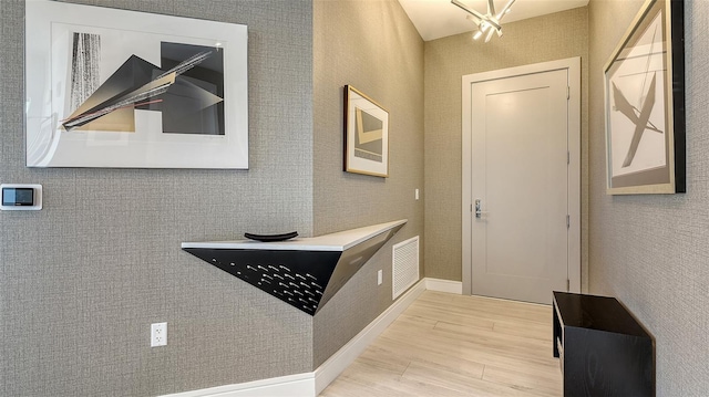 foyer entrance featuring a notable chandelier and light hardwood / wood-style floors