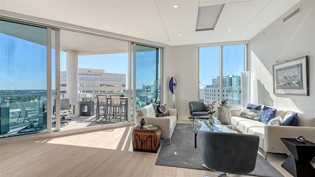 living room with expansive windows and light hardwood / wood-style flooring