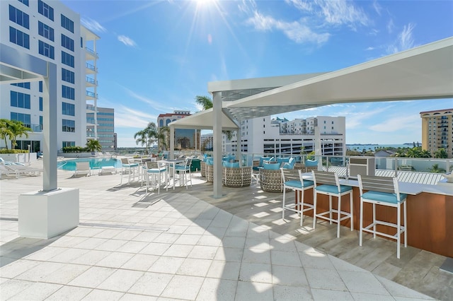 view of patio featuring a community pool and an outdoor bar