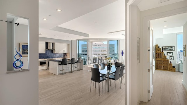 dining area featuring light hardwood / wood-style floors, sink, and expansive windows