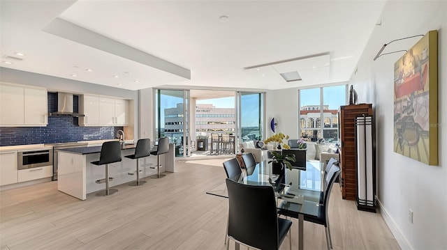 dining area with light hardwood / wood-style floors and expansive windows