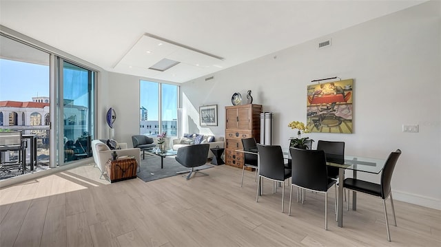 dining space featuring light hardwood / wood-style floors and expansive windows