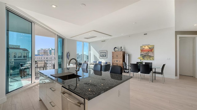 kitchen with sink, white cabinets, a kitchen island with sink, and plenty of natural light