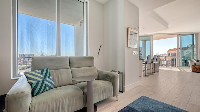 living area featuring light wood-type flooring and floor to ceiling windows