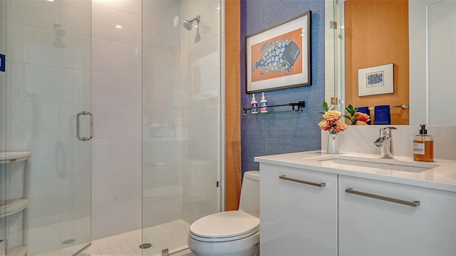 bathroom featuring toilet, a shower with shower door, and vanity