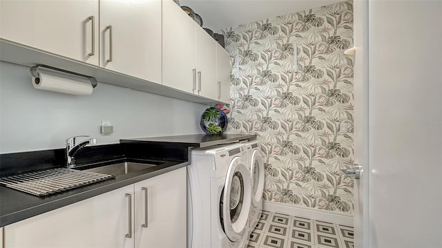 washroom with sink, washing machine and dryer, and cabinets