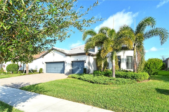 view of front of house with a garage and a front lawn