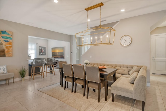 dining area with light tile patterned floors and a notable chandelier