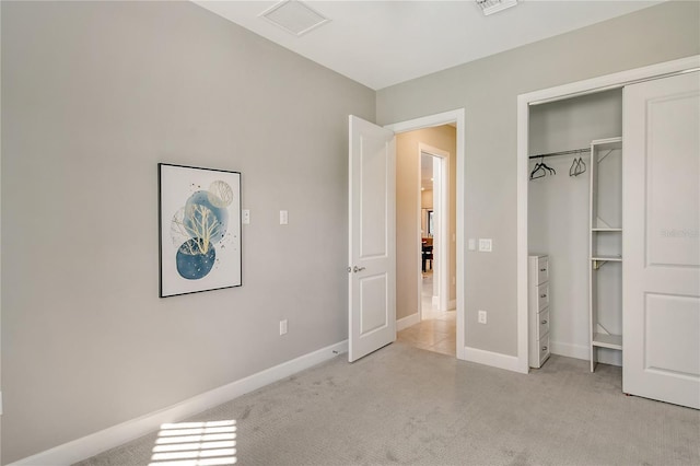 unfurnished bedroom with light colored carpet and a closet