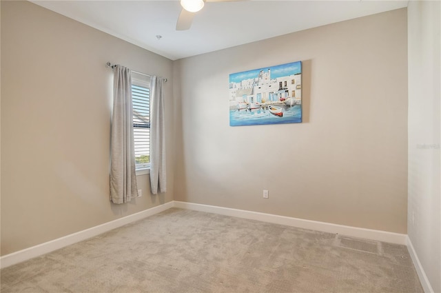 carpeted spare room with ceiling fan