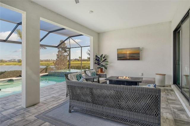 view of patio with a swimming pool with hot tub, a lanai, an outdoor living space with a fire pit, and a water view