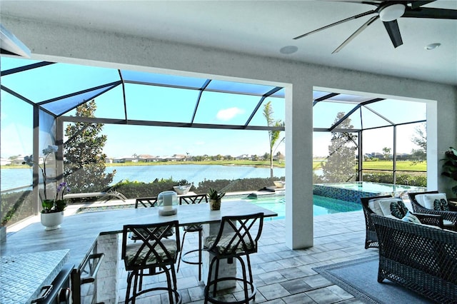 view of patio with a swimming pool with hot tub, ceiling fan, a water view, and glass enclosure