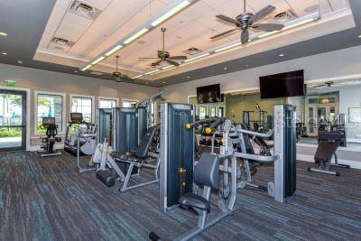 exercise room featuring a towering ceiling, a tray ceiling, and dark colored carpet