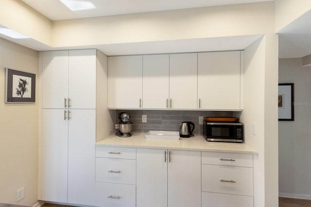 kitchen with white cabinets and backsplash