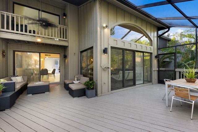 deck featuring glass enclosure, an outdoor hangout area, and ceiling fan