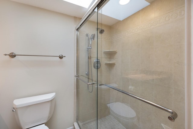 bathroom with a shower with shower door and toilet