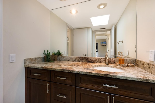 bathroom featuring vanity and a skylight