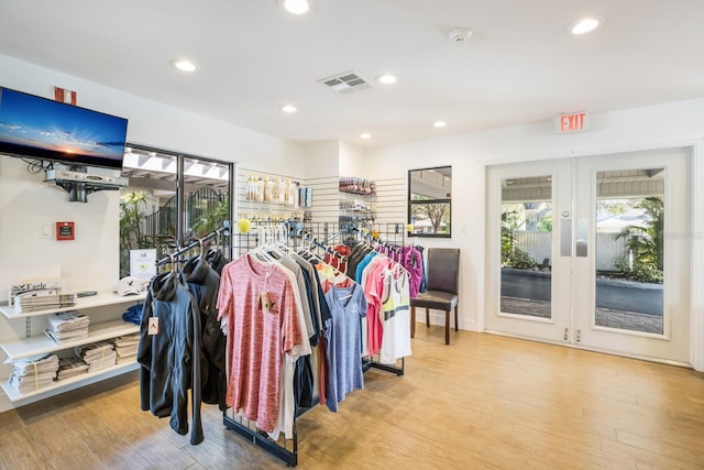 walk in closet with french doors and hardwood / wood-style flooring