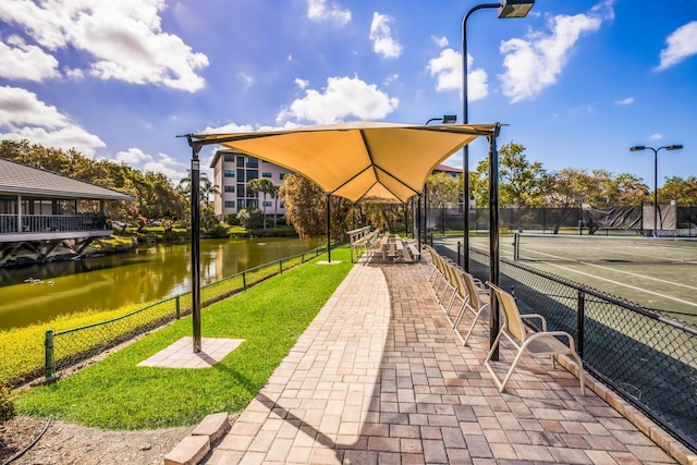 view of community featuring a water view and tennis court