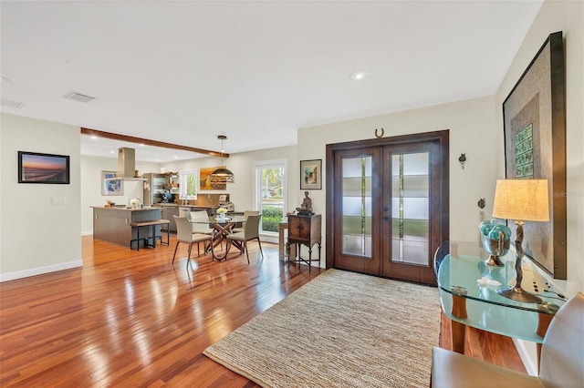 foyer with light hardwood / wood-style floors and french doors