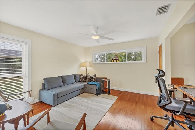 office space with ceiling fan, hardwood / wood-style floors, and a healthy amount of sunlight