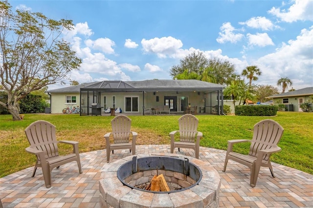 view of patio with glass enclosure, a grill, and a fire pit