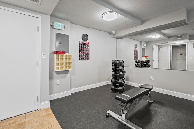 exercise area featuring a textured ceiling and electric panel