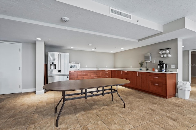 kitchen featuring sink, high end refrigerator, and a textured ceiling