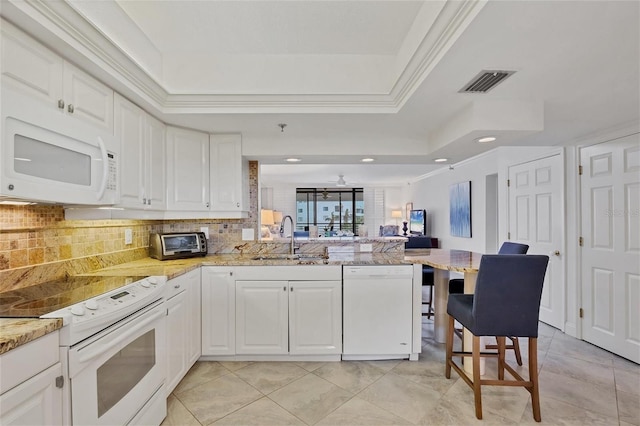 kitchen with white cabinets, kitchen peninsula, sink, and white appliances