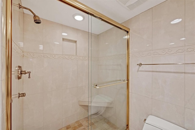 bathroom featuring walk in shower, tile walls, and toilet