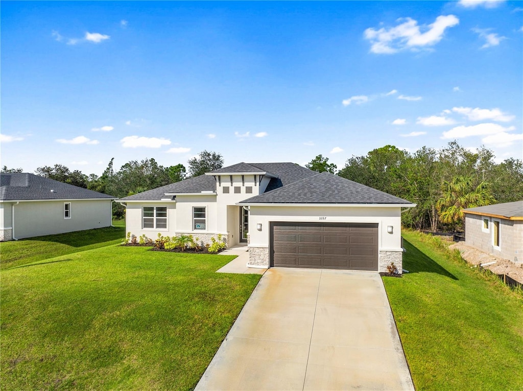 prairie-style house featuring a garage and a front yard