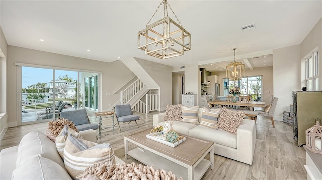 living room featuring light wood-type flooring and a chandelier