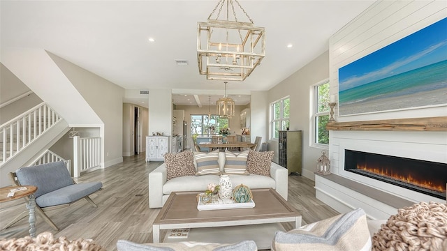 living room featuring plenty of natural light, a chandelier, and light hardwood / wood-style floors