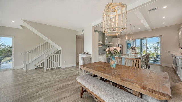 dining room with light wood-type flooring, a chandelier, a healthy amount of sunlight, and beamed ceiling