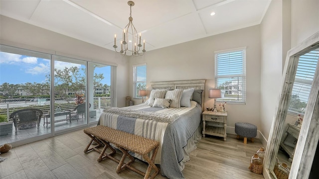 bedroom with light wood-type flooring, a notable chandelier, and access to exterior