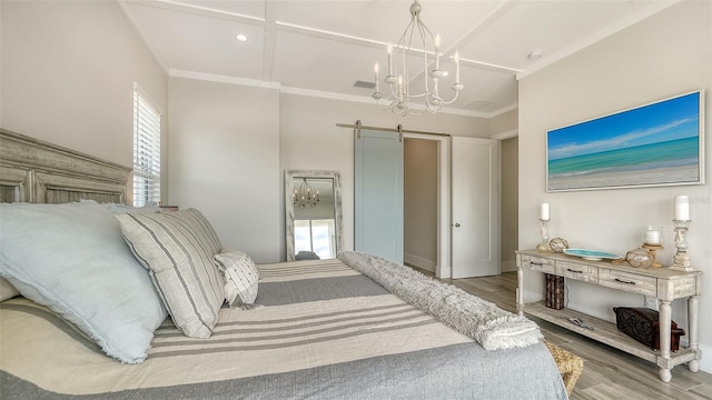 bedroom with a chandelier, ornamental molding, a barn door, and light wood-type flooring