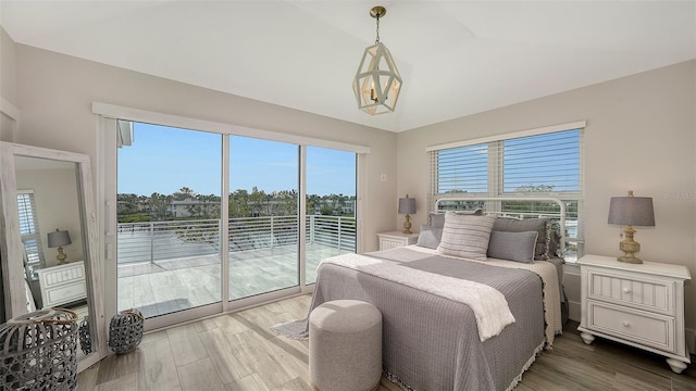 bedroom with lofted ceiling, access to exterior, and hardwood / wood-style flooring