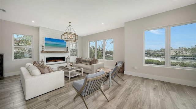 living room with an inviting chandelier, wine cooler, and light hardwood / wood-style flooring