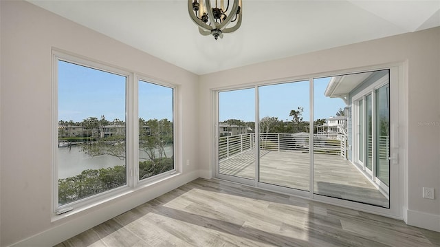 unfurnished sunroom featuring a water view