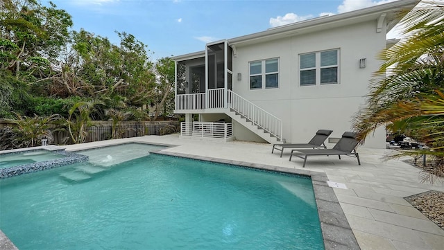 view of swimming pool with a patio area, a sunroom, and an in ground hot tub