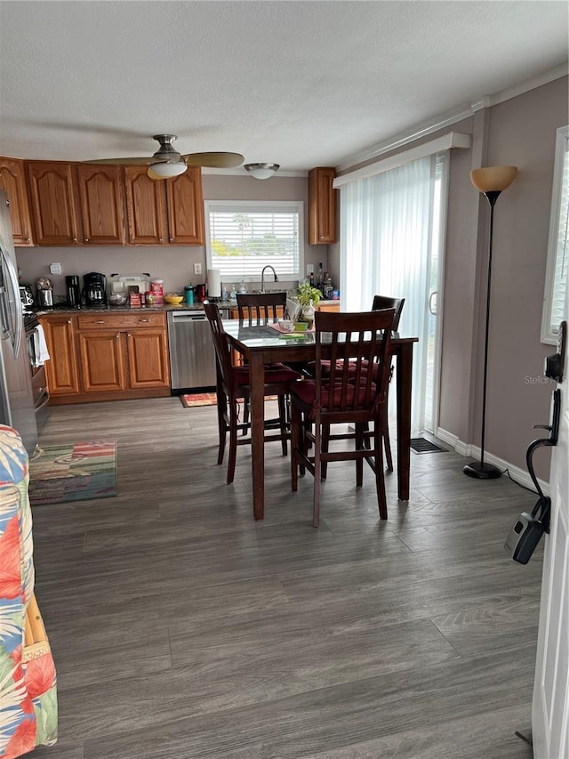 dining space with dark wood-type flooring, ceiling fan, and a textured ceiling